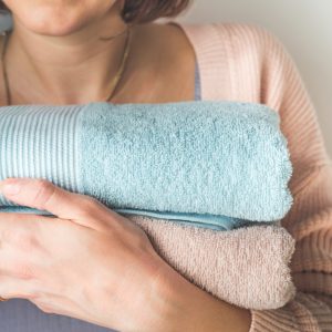 Woman holding clean folded towels